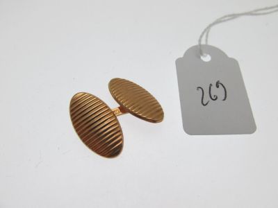 un gros plan sur une paire de boucles d'oreilles en or avec une étiquette de prix