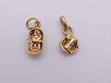 a pair of gold plated egyptian scart charms on a white background