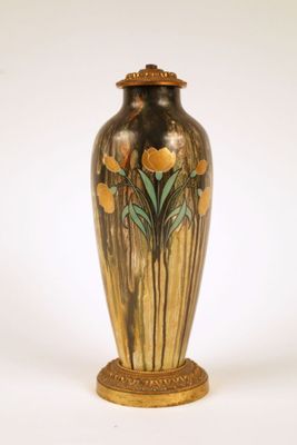 a gold vase with flowers on it on a white background