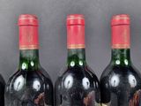 several bottles of wine are lined up on a shelf
