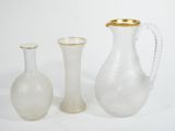 three glass vases sitting next to each other on a white surface