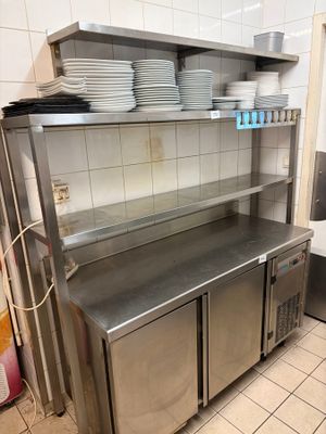 un plan de travail en acier inoxydable dans une cuisine, sur lequel sont posés des plats