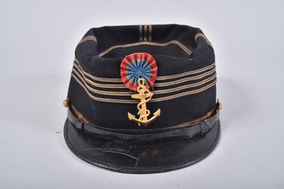 un chapeau noir orné d'une ancre dorée et d'un ruban