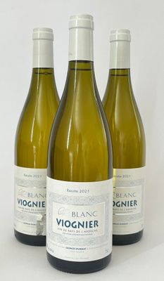 trois bouteilles de vin blanc sont alignées sur une surface blanche