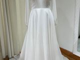 the wedding dress is on a mannequin stand in front of a window