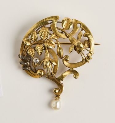 une image d'une broche en or avec une perle au centre