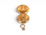 a small gold pocket watch with a key on it