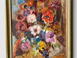 une peinture à l'huile représentant un vase de fleurs, dans un cadre doré accroché au mur