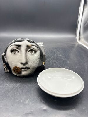 une petite assiette blanche sur laquelle est représentée une femme, à côté d'une autre petite assiette blanche