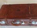 une valise marron posée sur une table blanche