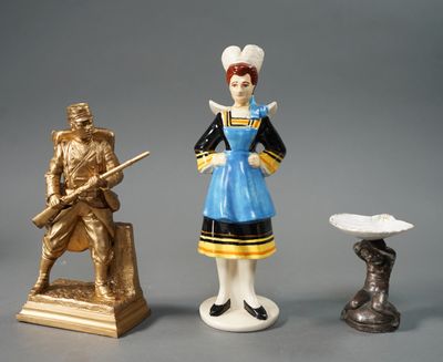 trois figurines représentant des personnes debout les unes à côté des autres