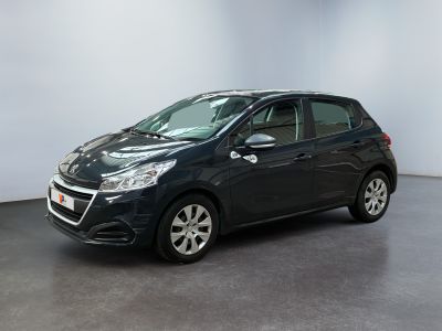 a black car is parked in a room with a white wall