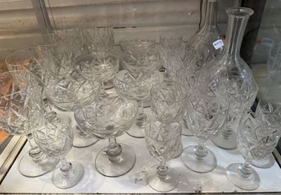 a lot of wine glasses and a bottle on a table