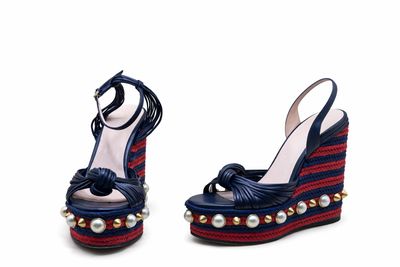 une paire de chaussures à talons compensés bleues et rouges, ornées de perles au niveau du talon