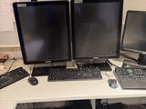 three computer monitors and a laptop on a desk