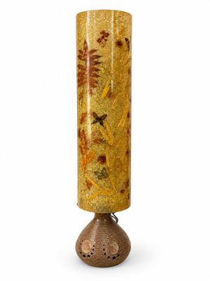 vase jaune et marron posé sur un socle en bois, sur fond blanc