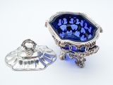 two silver and blue glass dishes on a white surface