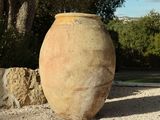 a large vase sitting in the middle of a gravel area