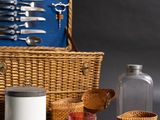 a wicker basket with silverware and a glass jar