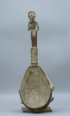 an old bronze figurine of a woman holding a baby on top of a vase