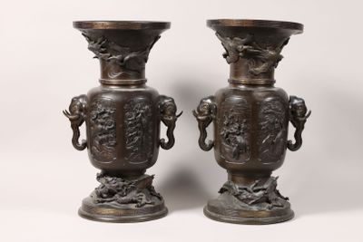 paire de vases anciens en bronze, munis d'anses et posés sur des socles