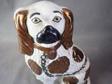 a ceramic dog with a chain around its neck