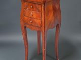 une petite table en bois avec deux tiroirs d'un côté et un tiroir de l'autre côté
