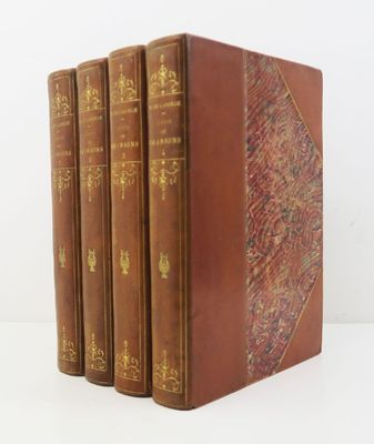 quatre livres sont alignés sur une surface blanche