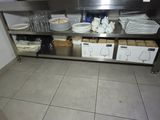 a stainless steel shelf with plates and glasses on it
