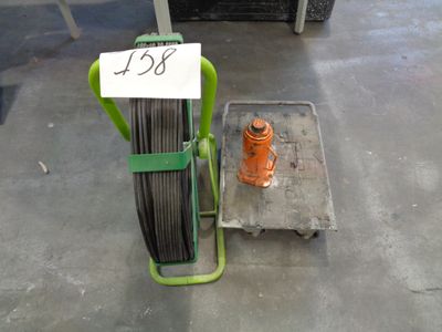 a cart that has some wires on it and a fire hydrant in the background