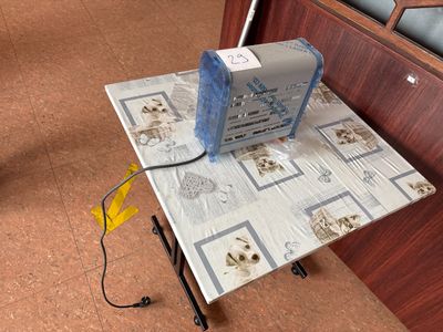 une petite table sur laquelle est posé un ventilateur