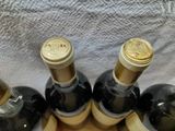 several bottles of wine are lined up in a row on a table