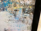 peinture abstraite représentant un paysage urbain, encadrée dans un cadre noir et accrochée au mur