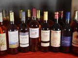 bottles of wine are lined up on a red table cloth