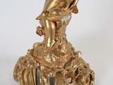 an image of a gold statue of a child on a pedestal