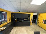 une cuisine jaune avec des placards noirs et des murs jaunes