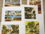 four paintings of different landscapes are displayed on a table