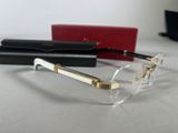 pair of clear glasses with gold rims on a table next to a red box