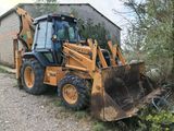 a backhoe of a construction vehicle that is parked in the dirt