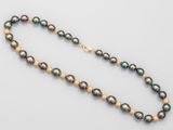 a black pearl and gold necklace on a white background
