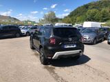 a lot of cars parked in a parking lot with mountains in the background