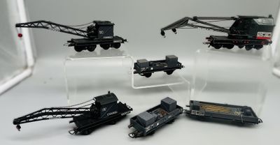 de nombreux petits trains exposés sur une surface blanche