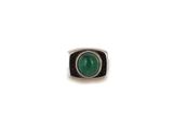 a close up of a ring with a green stone in it