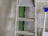 deux échelles posées l'une à côté de l'autre devant un mur