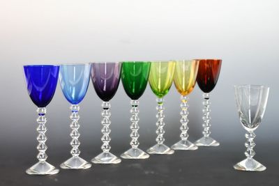 several different colored wine glasses are lined up in a row