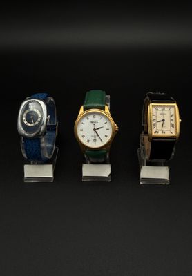 trois montres sont alignées les unes à côté des autres sur une surface noire
