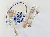 a plate with silverware and a blue and white plate with silverware on it