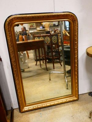 un miroir posé par terre à côté d'une table