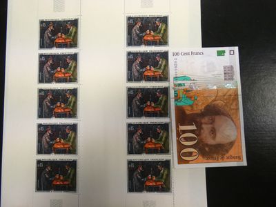 de nombreux timbres posés sur une table, avec la photo d'un homme