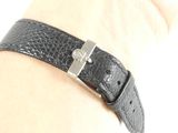 someone is wearing a black leather bracelet with a silver clasp